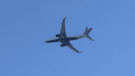 Airplane flying against clear blue sky.